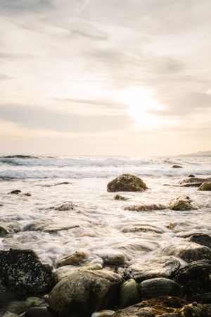 Stony seashore and waves at beautiful sunset