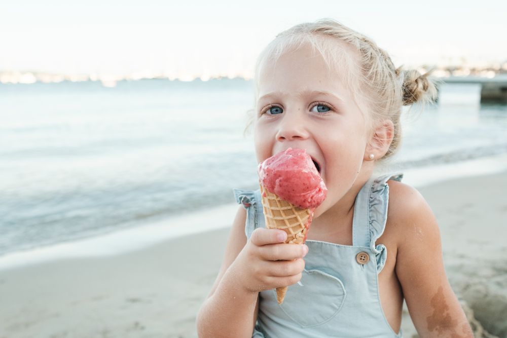 Happy girl enjoying ice cream on beach