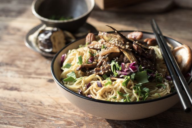 Miso noodles with egg plants and shiitake in bowl on table