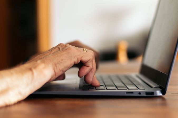 Unrecognizable older woman using the laptop