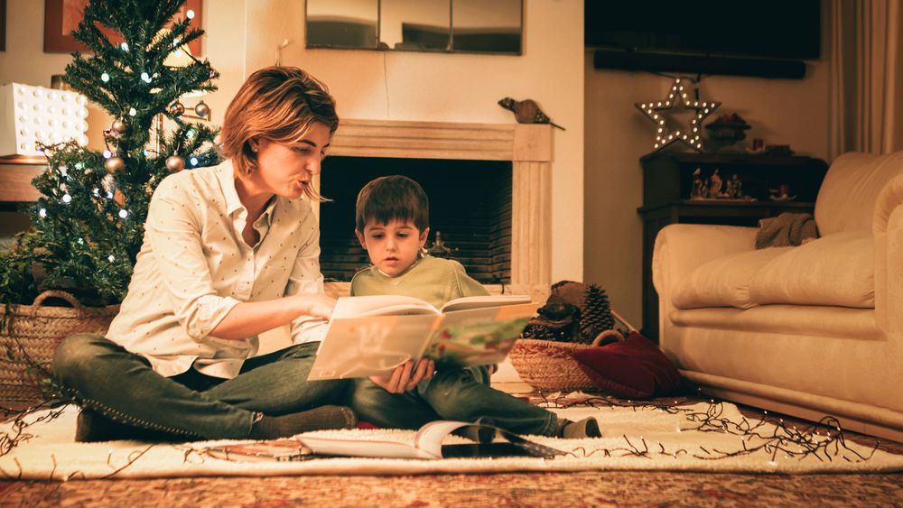 Mother reading book with son on Christmas eve