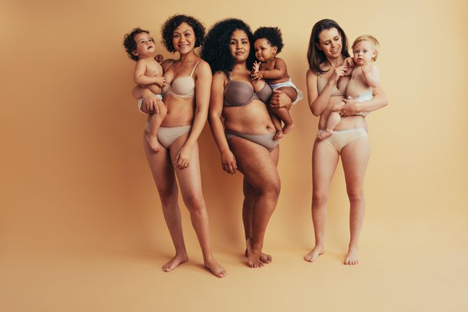 Real mothers standing comfortably in their postpartum bodies