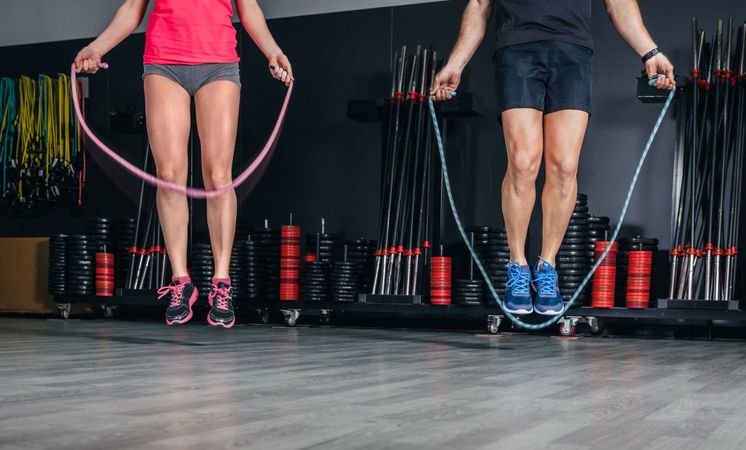 Legs of man and woman jumping rope in fitness class