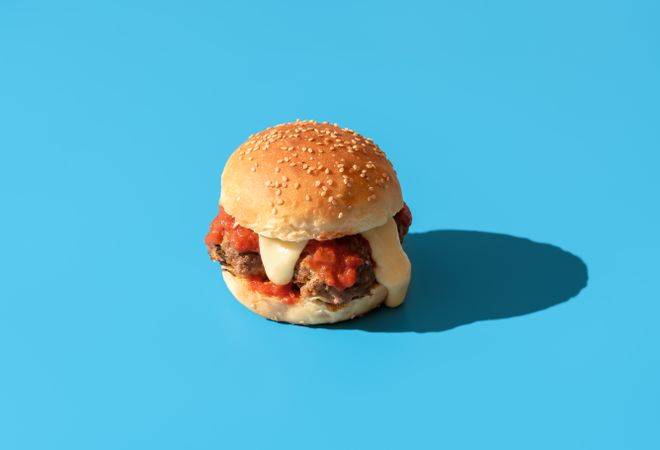 Burger with meatballs isolated on a blue background