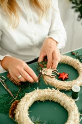 Woman decorating Christmas wreath at home