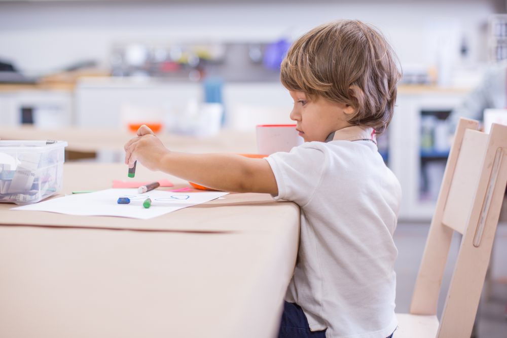 Boy at school drawing on paper