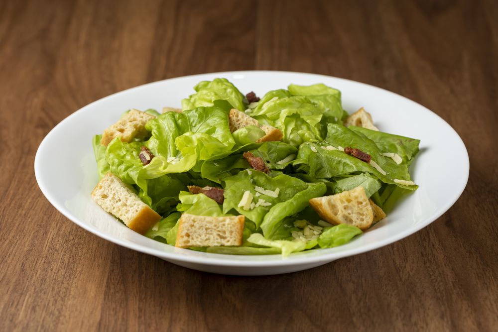 Caesar salad with croutons and bacon.
