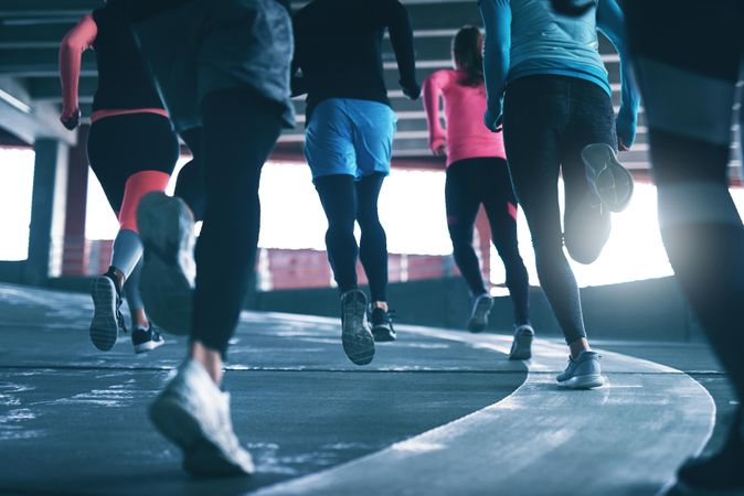 Shot of people legs in athletic gear running up a concrete incline