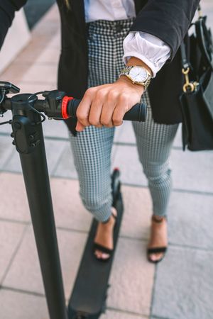 Unrecognizable businesswoman with e-scooter outdoors