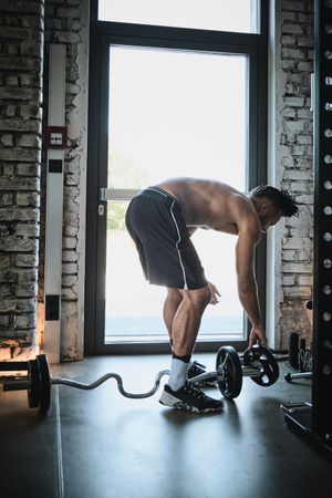 Black man exercising with barbell in gym