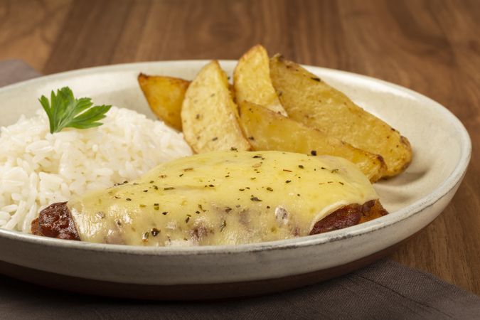 Parmigiana steak with rice and roasted potatoes. Typical Brazilian dish.