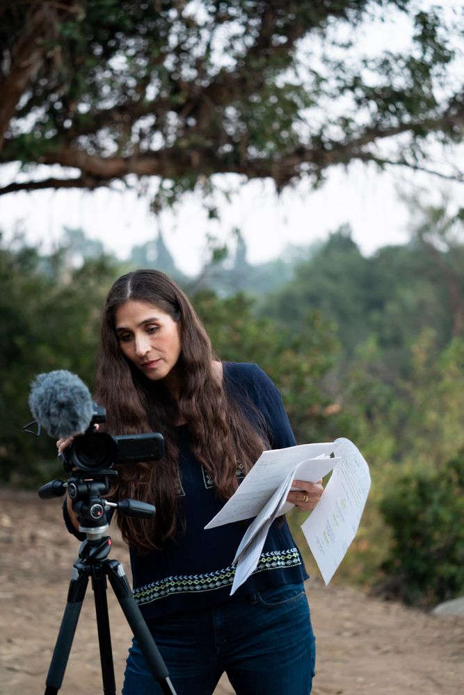 Female director looking through viewfinder on camera