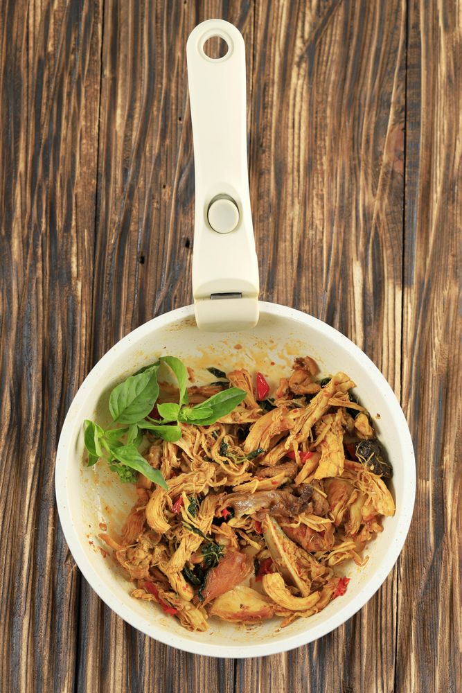 Looking down at skillet of Indonesian shredded chicken dish