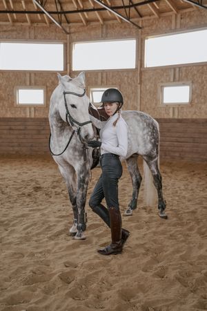 Rider with dapple gray horse in round arena