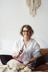 Woman Working From Home In Bed