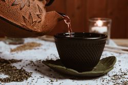 Aromatic tea dates and clay teapot on table
