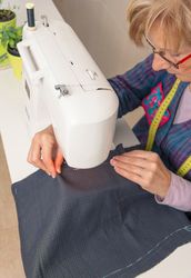 Mature seamstress woman working on sewing machine