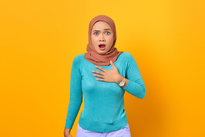 Muslim woman taken aback with hand on chest