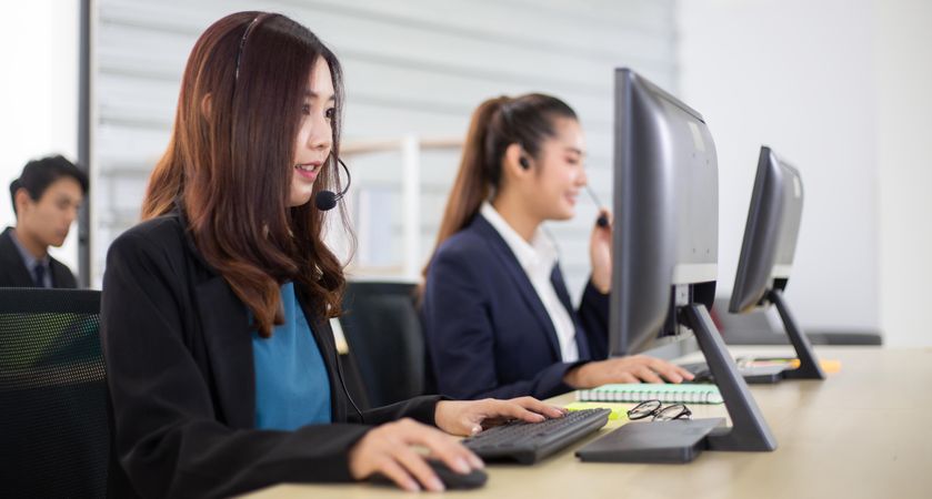 Banner of business call center with women and man in headsets sitting in office desk using computer