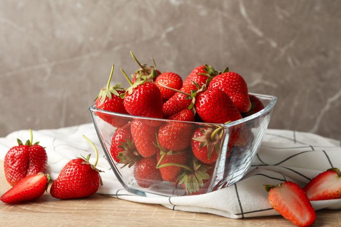 Bowl with tasty strawberry on wooden table. Summer berry