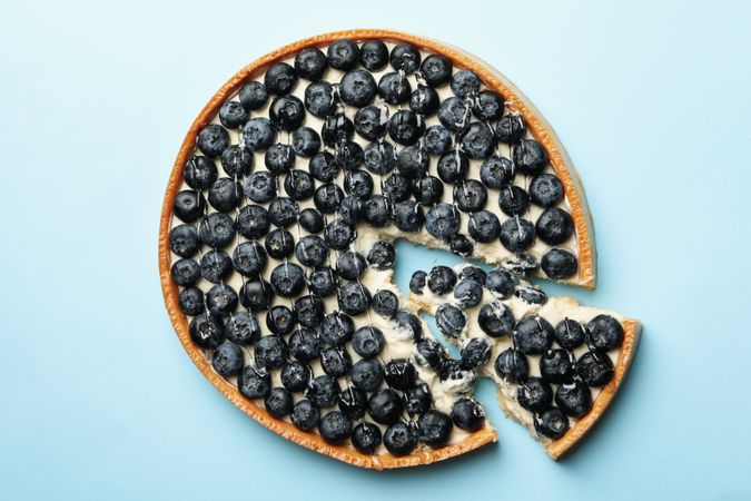 Blueberry pie on blue background, top view