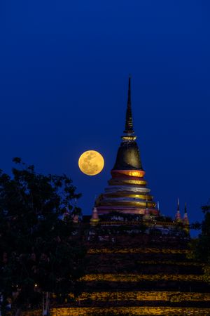 Super moon in night sky and silhouette of ancient pagoda is named Wat Ratchaburana, Phitsanulok in Thailand
