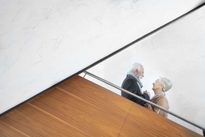 Older couple looking at each other and smiling on stairs