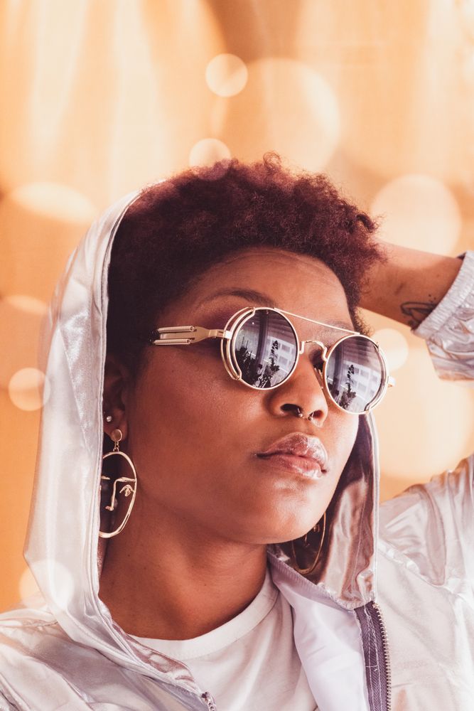 Woman in light hoodie wearing silver framed aviator sunglasses