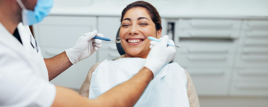 Smiling woman in dental clinic with doctor