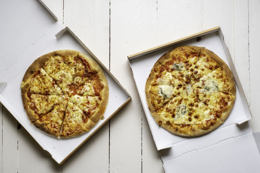 Two pizza in cardboard boxes