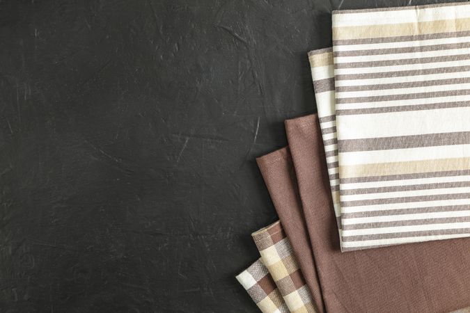 Fabric napkins on dark background, space for text
