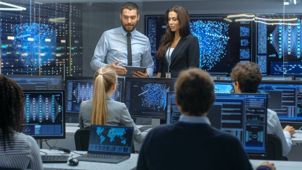 Head of the Department and Project Manager Discuss Work Process Using Data on a Tablet Computer.