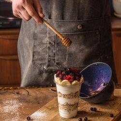 Chef adding honey to granola parfait on top