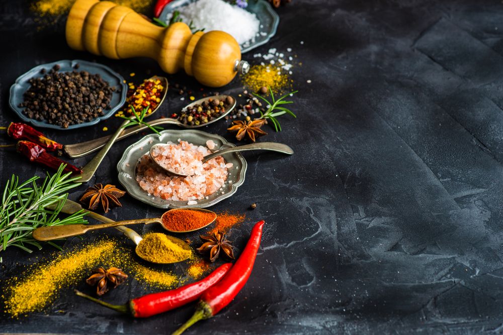 Spices and salt on dark counter with copy space