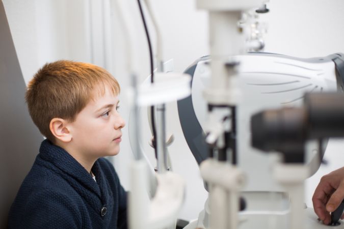 Optician testing a boy's eyes