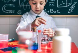 Serious kid playing with chemistry set