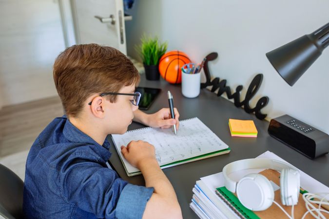 Left handed teenager doing homework in his bedroom