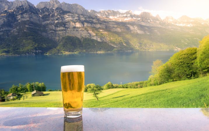 Glass of beer in a summer alpine scenery