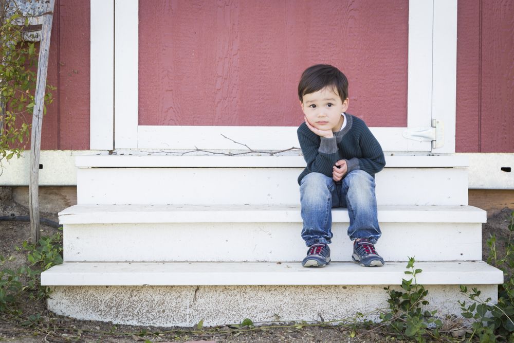 Cute Young Boy Sitting on the Steps of a Barn