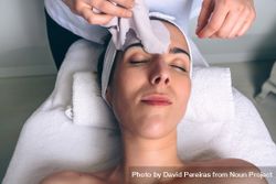 Beautician's hands removing facial mask from woman 0gXYOj