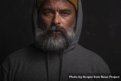 Portrait of middle aged man with gray hoodie with gloomy expression against 5oKGm5