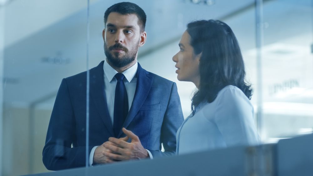 Top Manager and Female Executive Outlining Company Optimization Plan on a Glass Board,