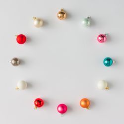 Circular border of colorful Christmas bauble decorations on light background