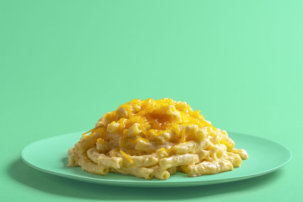 Mac and cheese on a green plate, close-up