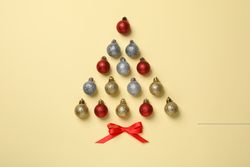 Christmas tree made of baubles on beige background, space for text