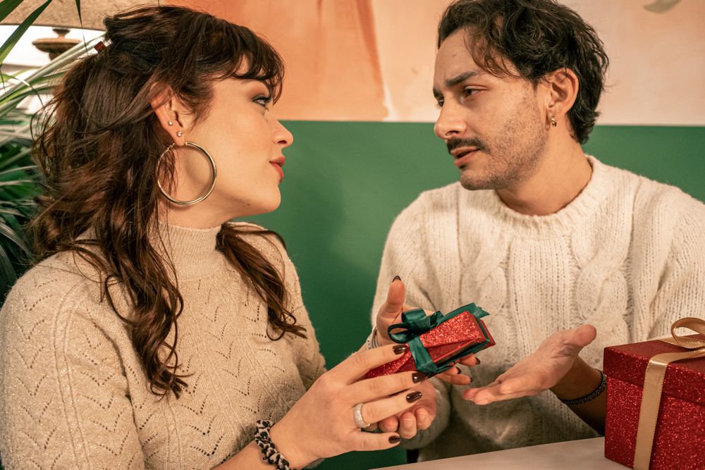 Romantic couple exchanging gifts during a Christmas celebration