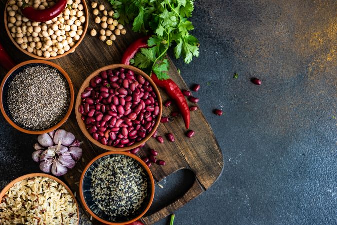 Bowls of different dried beans on cutting board