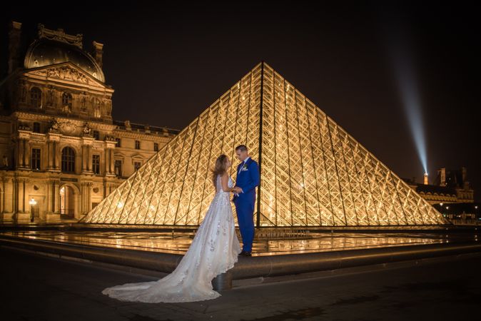 Just married couple in wedding clothing cuddling under moonlight