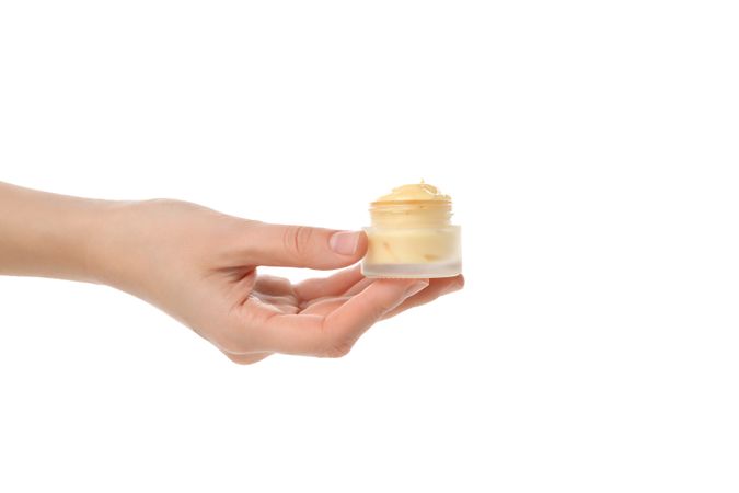cream in hands, isolated on light background.