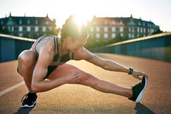 Woman crouching down stretching her legs